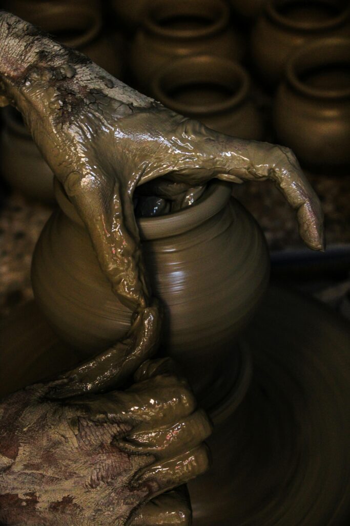 Close-up of hands shaping clay into pottery on a wheel, showcasing traditional craftsmanship.