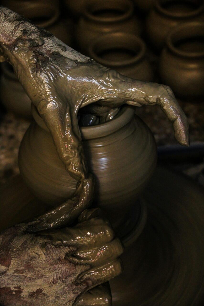 Close-up of hands shaping clay into pottery on a wheel, showcasing traditional craftsmanship.